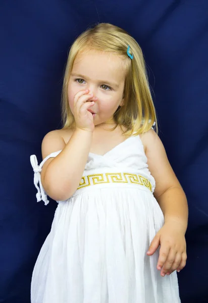 Hermosa niña rubia sosteniendo un dedo en su boca — Foto de Stock