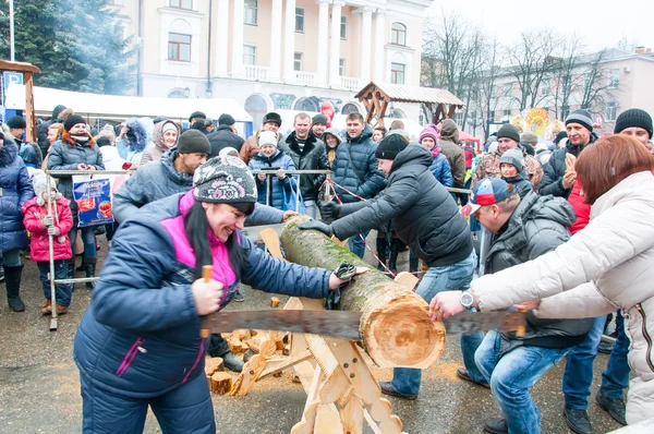 Undefined people take part in contest saw up the log during Maslenitsa celebration in Bryansk city. — Stock Photo, Image