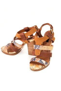 Yılan deri üzerinde beyaz izole kadın açık-toe sandal çifti dekore.