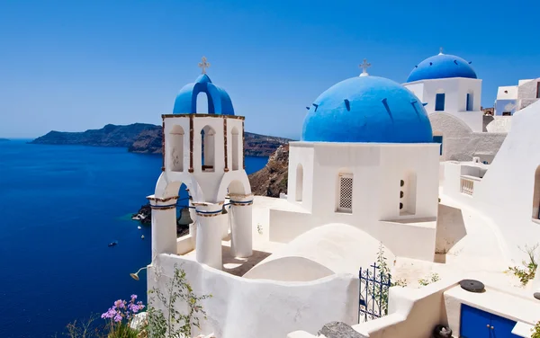 Oia Orthodox churches and the bell tower on Santorini island, Greece.