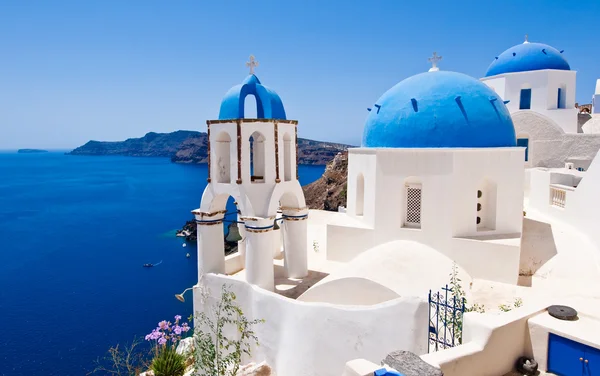 Oia Orthodox churches and the bell-tower. Santorini island, Greece.