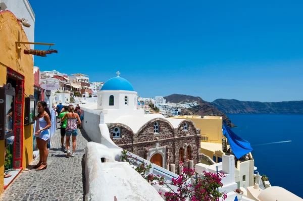 SANTORINI, OIA-28 DE JULIO: Los turistas van de compras el 28 de julio de 2014 en la ciudad de Oia en la isla de Santorini, Grecia. Oia es una pequeña ciudad en las islas de Thira (Santorini) y Therasia, en las Cícladas, Grecia. . — Foto de Stock