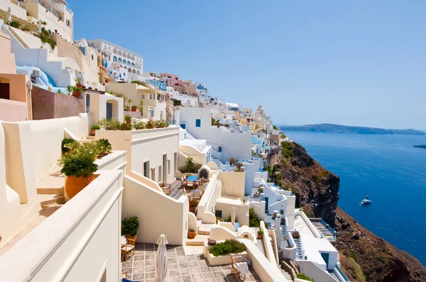 Fira traditional architecture with whitewashed buildings carved into the rock on the edge of the caldera cliff on the island of Thira (Santorini), Greece.