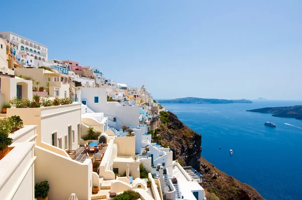Panorama of Fira with whitewashed buildings carved into the rock on the edge of the caldera cliff on the island of Thira (Santorini), Greece. — Stock fotografie