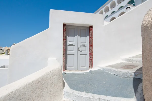 Fira Town caldera uçurumun kenarına kayaya oyulmuş evin girişine. Thira (Santorini), Yunanistan.