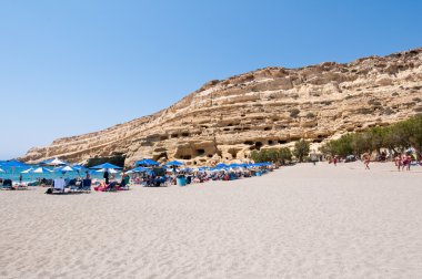 Crete, Yunanistan-Temmuz 22: Tatilciler Matala plajda Temmuz'da mağaralar ile 22,2014 Crete, Yunanistan.