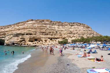Crete, Yunanistan-Temmuz 22: Tatilciler Matala plaj üzerinde Temmuz Libya Deniz mağaraları ile 22,2014 Crete, Yunanistan.