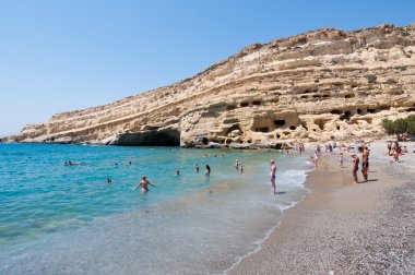 Crete, Yunanistan-Temmuz 22: Temmuz'da mağaralar ile Matala sahilde turistler, kalabalık 22,2014 Crete, Yunanistan.