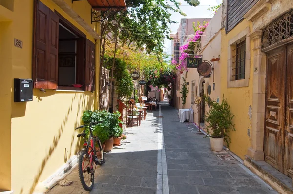 RETHYMNO, CRETE-JULY 23: Rua estreita com restaurantes e bares acolhedores em 23 de julho de 2014 na cidade velha de Rethymno. Ilha de Creta, Grécia . — Fotografia de Stock
