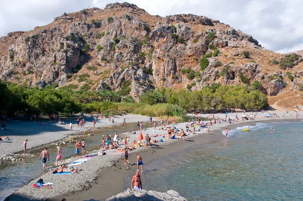 CRETE, GRÉCIA-JULHO 23: Os turistas têm um resto na praia de Preveli em julho 23.2014 em Creta, Greece. A praia de Preveli está situada a 40 km ao sul da cidade principal e é a praia mais idílica de Creta . — Fotografia de Stock