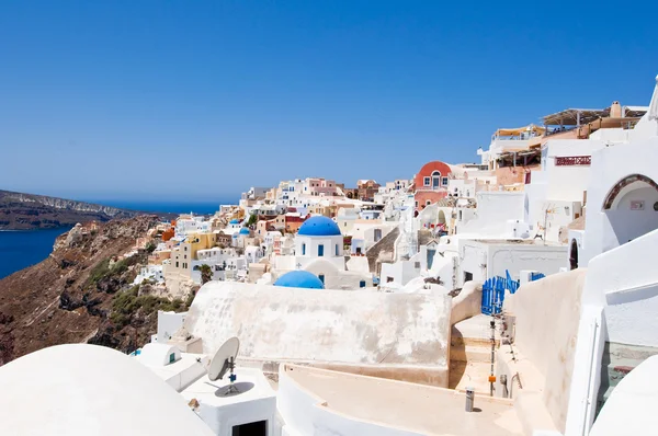 Oia con tipiche case dipinte di bianco e blu sull'isola di Santorini, Grecia . — Foto Stock