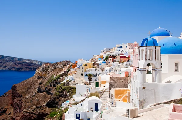 Oia kerk met blauwe koepels en de witte klok op het eiland Santorini, Griekenland — Stockfoto