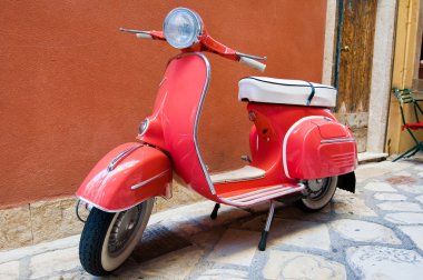 CORFU-AUGUST 22: Classic Vespa scooter parked on Kerkyra street on August 22, 2014 on Corfu island. Greece. Vespa is an Italian brand of scooter manufactured by Piaggio.