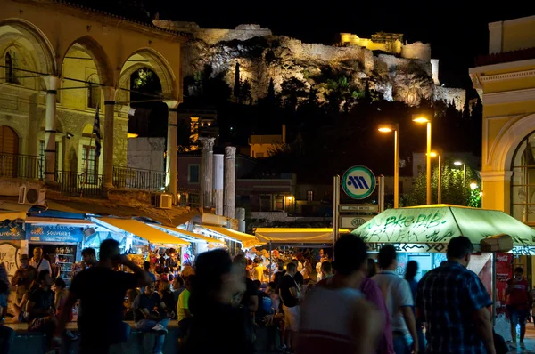Athene-22 augustus: Nachtleven op Monastiraki plein met de Akropolis van Athene op de achtergrond op 22 augustus 2014 in Athene, Griekenland. — Stockfoto