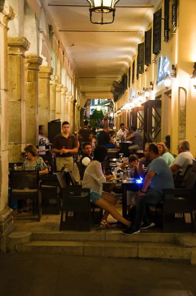 CORFU-AUGUST 25: Tourists have dinner in a local restaurant on the Liston of Corfu on August 25, 2014 in Kerkyra town on the Corfu island, Greece. — Stock Photo, Image