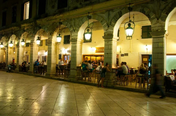 Corfu-augustus 22: The Liston van Corfu nachts in Kerkyra stad met de rij van lokale restaurants en de menigte van mensen op 22 augustus 2014 op het eiland Corfu in Griekenland. — Stockfoto