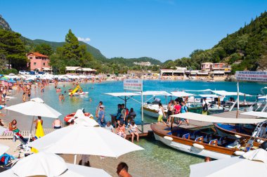 Corfu-Ağustos 26: Palaiokastritsa plaj kalabalık sahilde güneşlenirken tatilciler ile Ağustos 26,2014 Korfu, Yunanistan. Palaiokastritsa kuzey batısında Korfu ünlü plajları ile bir köydür.