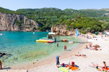 Corfu-Ağustos 26: Palaiokastritsa beach, insanlar sahilde Ağustos'ta güneşlenmek 26,2014, Corfu Island, Yunanistan. Palaiokastritsa kuzey batısında Korfu ünlü plajları ile bir köydür.