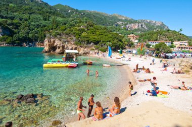 Corfu-Ağustos 26: Palaiokastritsa beach, insanlar sahilde Ağustos'ta güneşlenmek, Corfu, Yunanistan adada 26,2014. Palaiokastritsa kuzey batısında Korfu ünlü plajları ile bir köydür.