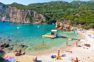 Corfu-Ağustos 26: Ünlü Palaiokastritsa beach, insanlar sahilde Ağustos'ta güneşlenmek 26,2014 Korfu, Yunanistan. Palaiokastritsa kuzey batısında Korfu ünlü plajları ile bir köydür.