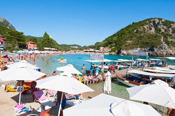 CORFU-AUGUST 26: Palaiokastritsa beach with crowd of people sunbathing on the beach August 26,2014 on Corfu, Greece. Palaiokastritsa is a village with famous beaches in the North West of Corfu. — Stock Photo, Image