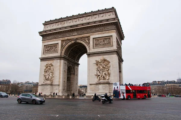 PARIS-JANUARY 10: The Arc de Triomphe with traffic around on January 10,2013 in Paris. The Arc de Triomphe is situated at the western end of the Champs-Élysées in Paris, France. — Stock Photo, Image