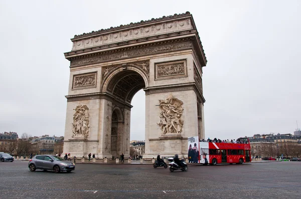 PARIS-JANUARY 10: The Arc de Triomphe with traffic around on January 10,2013 in Paris. The Arc de Triomphe is situated at the western end of the Champs-Élysées in Paris, France. — Zdjęcie stockowe