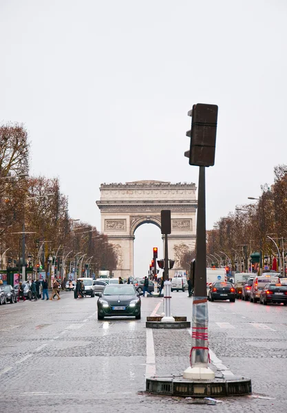 Paris-januar 10: avenue des champs-élysées mit dem Triumphbogen bei schlechtem Wetter am 10. januar 2013 in paris. — Stockfoto