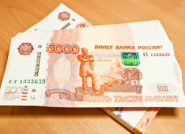 Российские купюры в пять тысяч рублей на деревянном фоне . — стоковое фото