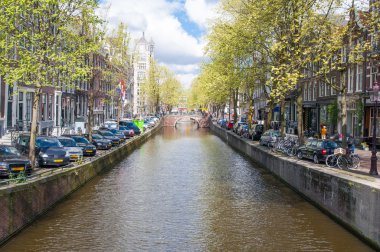 Banka boyunca park edilmiş arabalar ile Amsterdam kanal. Hollanda.