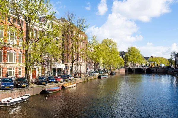 Amsterdamském kanále s lodí podél břehu řeky na jaře. Nizozemsko. — Stock fotografie