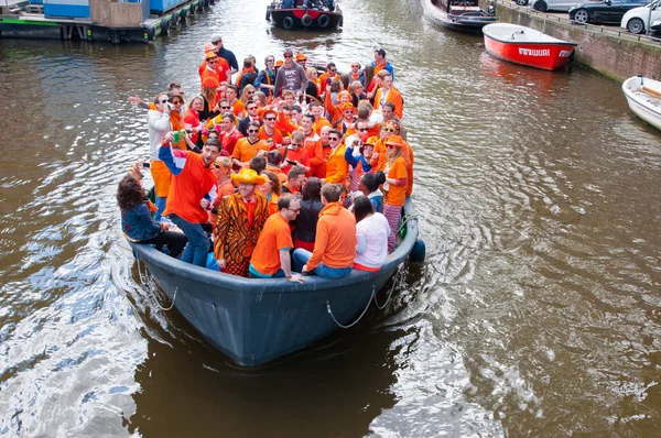 AMSTERDAM,NETHERLANDS-APRIL 27:  Crowd of local people dressed in orange celebrate King's Day in a boat on April 27,2015 in Amsterdam. — Stock Photo, Image