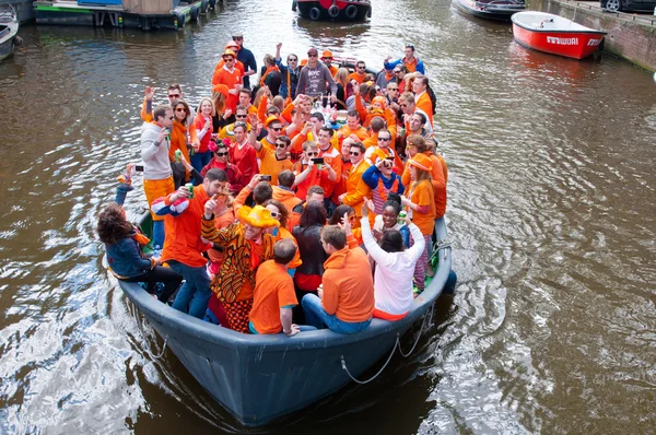 Amsterdam, Nederland-April 27: Menigte van mensen gekleed in oranje King's dag vieren in een boot op April 27,2015 in Amsterdam. — Stockfoto