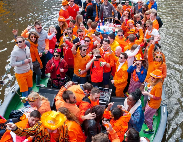 Amsterdam, Nederland-27 April: Locals gekleed in oranje vieren Konings dag op een boot op April 27,2015 in Amsterdam. — Stockfoto