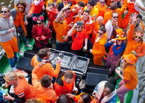 Amsterdam, Nederland-April 27: Mensen in oranje kleding King's overdag op een boot op April 27,2015 in Amsterdam. — Stockfoto