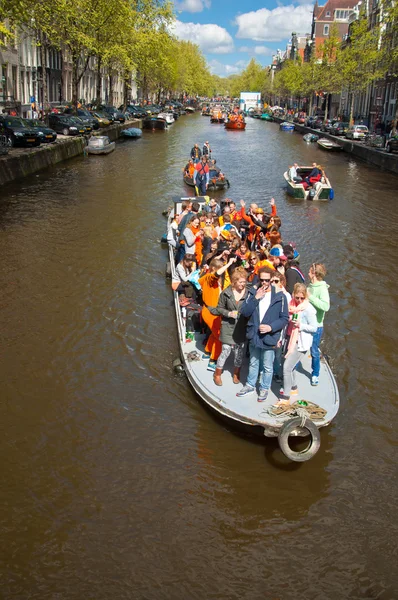 Amsterdam, Nederland-April 27: Boot partij langs Amsterdamse grachten op April overdag King's 27,2015 in Amsterdam. — Stockfoto