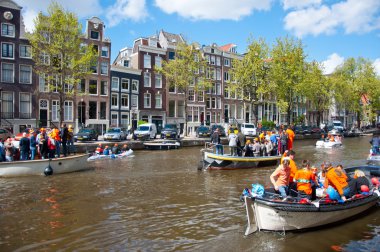 AMSTERDAM,NETHERLANDS-APRIL 27: Amsterdam canal full of boats during King's Day on April 27, 2015, the Netherlands.