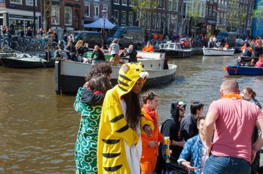 AMSTERDAM-APRIL 27: Locals and tourists solemnize King's Day along the Singel canal on April 27,2015.