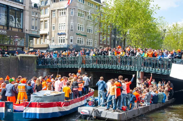 AMSTERDAM, PAÍSES BAJOS-ABRIL 27: Barco de fiesta con multitud de personas en el puente en el Día del Rey el 27 de abril de 2015 . — Foto de Stock