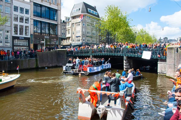 AMSTERDAM-ABRIL 27: Paty barco en el canal de Singel, multitud de personas en el puente en el Día del Rey en abril 27,2015 . — Foto de Stock