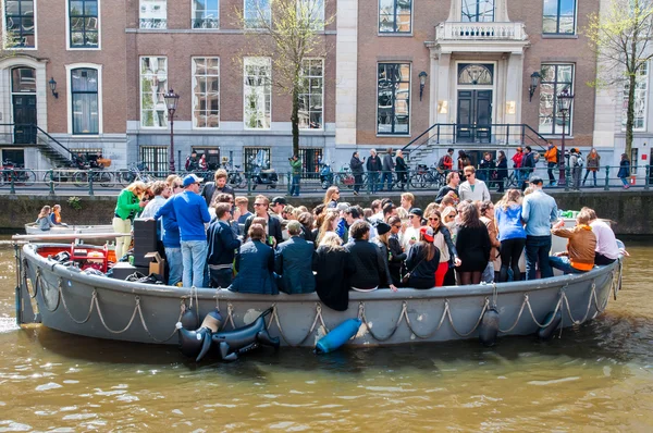 AMSTERDAM, PAÍSES BAJOS-ABRIL 27: Los lugareños y turistas en barco de fiesta a través de los canales de Amsterdam durante el Día del Rey en abril 27,2015 . — Foto de Stock