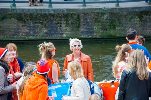 AMSTERDAM-APRIL 27: Happy Locals and tourists in orange have fun on a boat during King's Day on April 27,2015, the Netherlands. — Stok fotoğraf