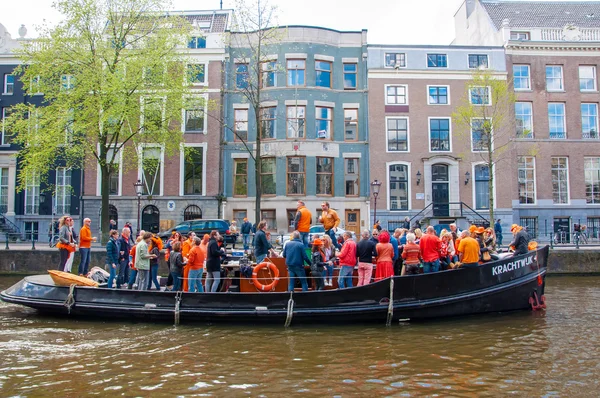 AMSTERDAM-APRIL 27: Locals and tourists have dance party on a boat King's Day along the Singel canal on April 27,2015, the Netherlands. — Stockfoto