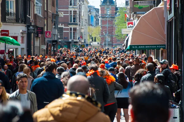 Amsterdam-April 27:Thousands mensen op straat in Amsterdam, Rijksmuseum op de achtergrond op April overdag King's 27,2015, Nederland. — Stockfoto