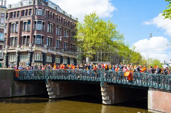 АМСТЕРДАМ-АПРЕЛЬ 27: Толпа людей смотрит фестиваль на мосту во время Дня короля (Koningsdag) 27 апреля 2015 . — стоковое фото