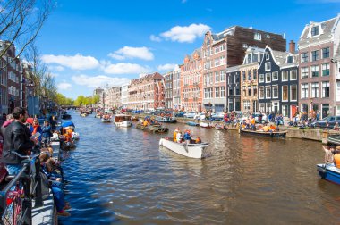 AMSTERDAM-APRIL 27: Locals and tourists celebrate King's Day along the Singel canal on sunny day on April 27,2015.
