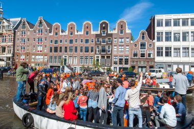 AMSTERDAM-APRIL 27: Local people and tourists on the boats participate in celebrating King's Day through Singel canal on April 27,2015.