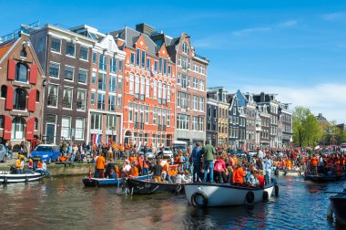 AMSTERDAM-APRIL 27: People on the boats participate in celebrating King's Day through Amsterdam canal on April 27,2015 the Netherlands.