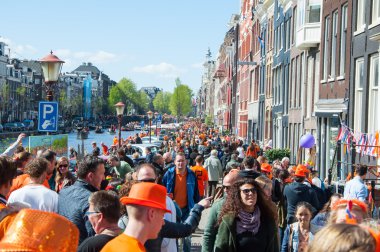 AMSTERDAM-APRIL 27: Locals and tourists celebrate King's Day along bank of Singel canal on April 27,2015, the Netherlands.