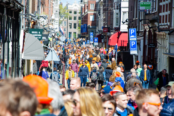 AMSTERDAM-APRIL 27: Crowd of people on Amsterdam busy street celebrate King's Day on April 27,2015, the Netherlands.
